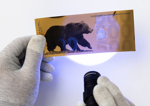 half gram 24k gold bill shown with uv security features under black light