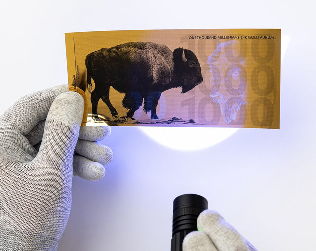 one gram 24k gold bill shown with uv security features under black light