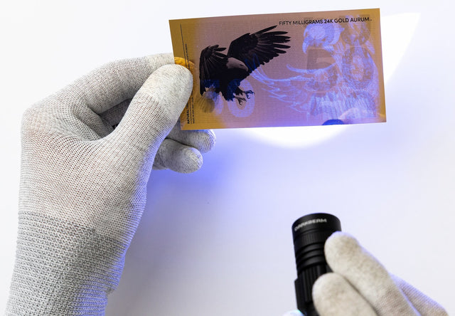 50 milligram 24k gold bill shown with uv security features under black light