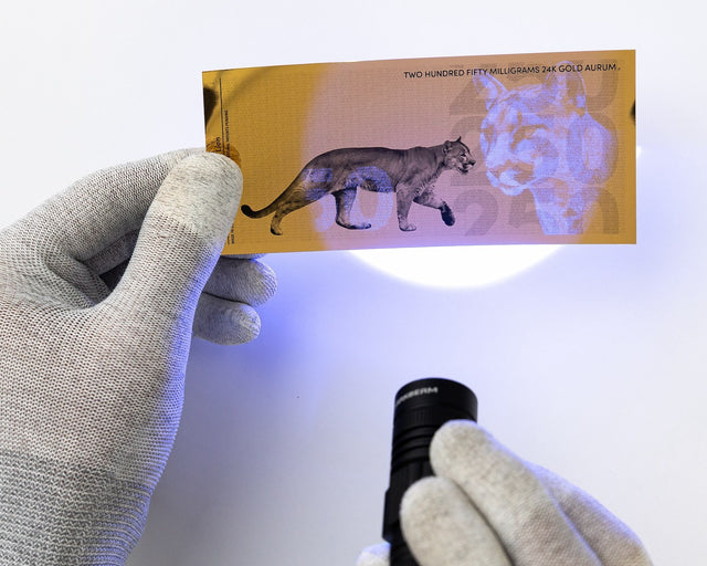 250 milligram 24k gold bill shown with uv security features under black light